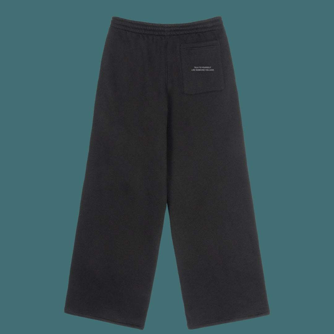 Black pants with a small pocket on a teal background