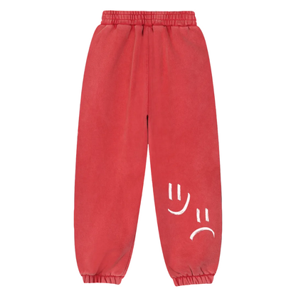 Red sweatpants with white smiley face designs on a teal background