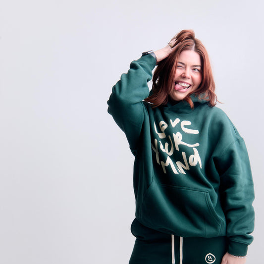 Person wearing a green hoodie and pants with text on a white background