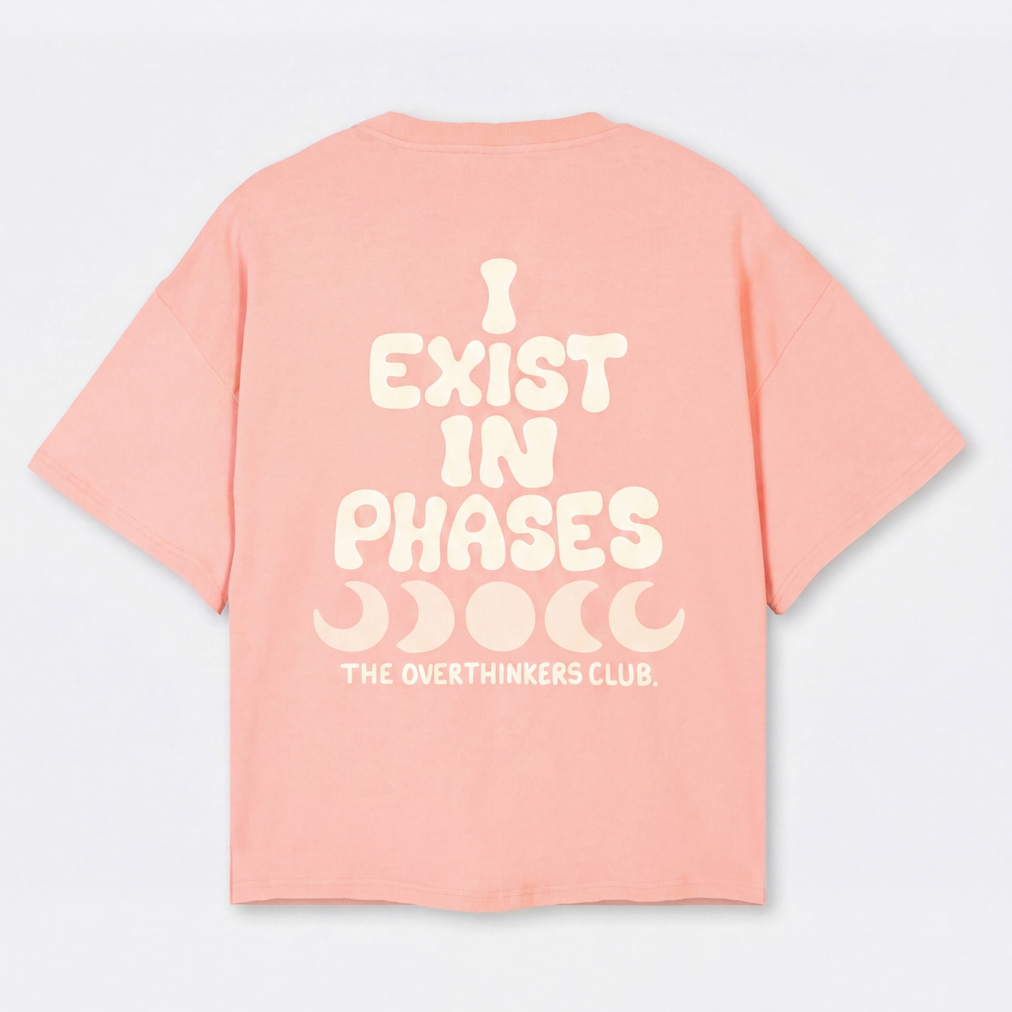 Pink t-shirt with white text 'I EXIST IN PHASES' on a light gray background